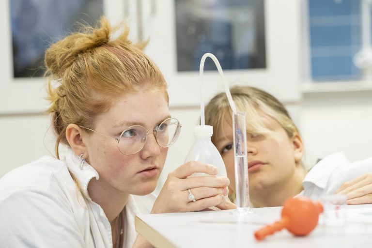 Två koncentrerade elever laborerar.