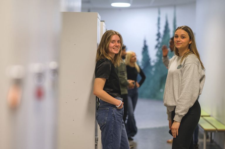 Två glada elever i skolans korridor. 