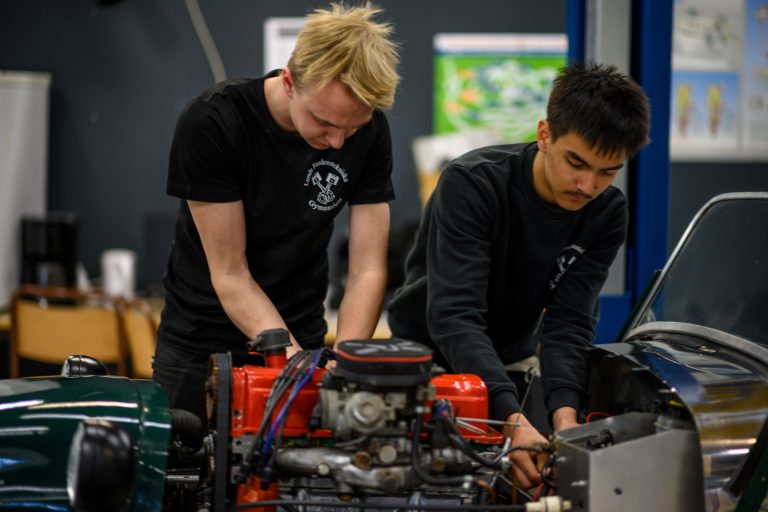 Två elever arbetar med en av våra projektbilar, en Lotus.