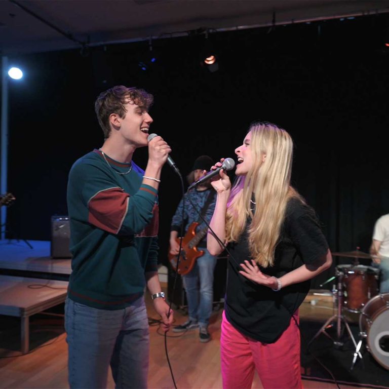 Två elever sjunger tillsammans på scen