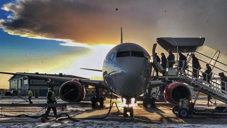 En morgonbild från flygplatsen med passagerare onboarding och bagagelastning, ett arbetsmoment för en flygplatstekniker 